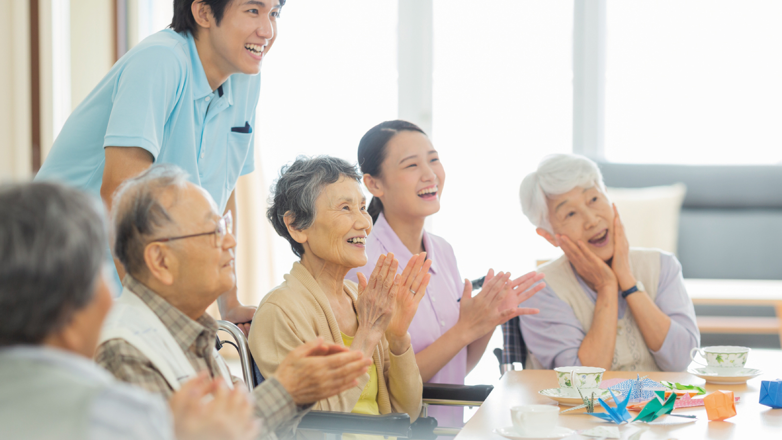 職員と入居者がテーブルで楽しくレクリエーション活動をしている風景